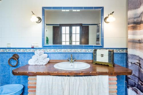 a bathroom with a sink and a mirror at Casa Rural Loma El Letrao in Almogía