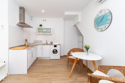 a kitchen with white cabinets and a table and a sink at Apartamento Luna in Barbate