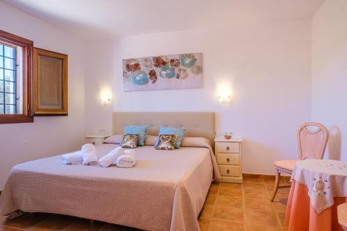 a bedroom with two beds and a table at Casa Cristina Ibiza in Sant Carles de Peralta