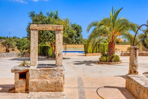 a stone monument in a park with palm trees at Finca Buniferri in Llucmajor