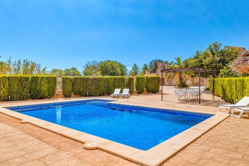 a swimming pool with chairs and a gazebo at Finca Buniferri in Llucmajor