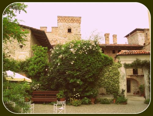 a building with a tree and a bench in front of it at Castello Di Strambinello in Strambinello