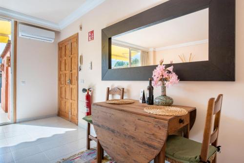 a dining room with a wooden table and a mirror at Apartament Carla in Port de Soller