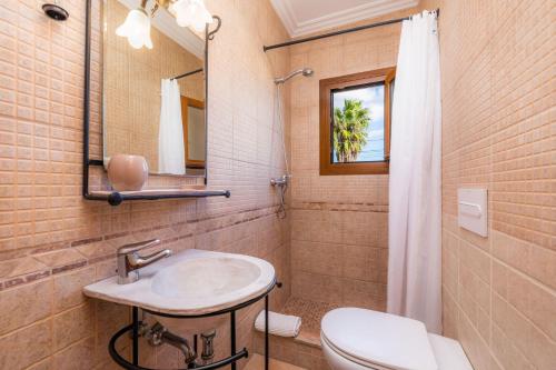 ein Badezimmer mit einem Waschbecken, einem WC und einem Spiegel in der Unterkunft Los tres soles in Portocolom