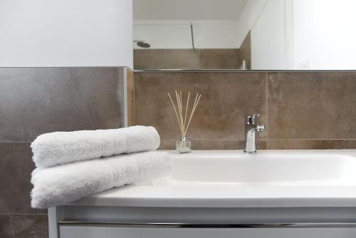 a bathroom with a white sink and towels at Appartamenti Dama 2 in Bardolino