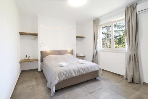 a bedroom with a bed and a window at Appartamenti Dama 2 in Bardolino