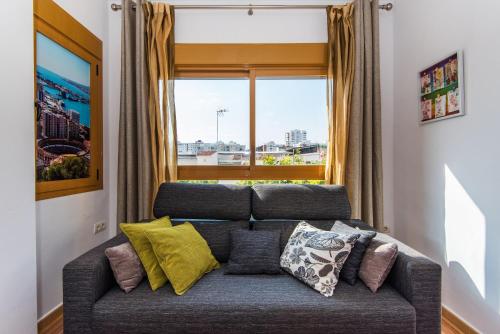 un sofá en una sala de estar con ventana en Loft, en Málaga