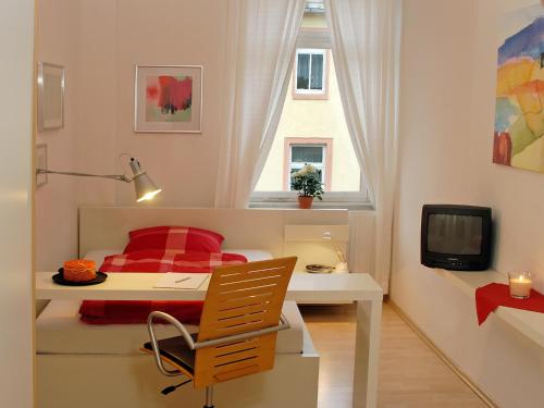 a bedroom with a desk and a bed and a window at Pension Müllers Alte Backstube in Reichenbach im Vogtland