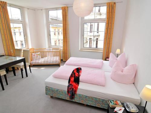 1 dormitorio con cama con almohadas rosas y escritorio en Pension Müllers Alte Backstube en Reichenbach im Vogtland
