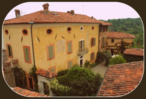 a large yellow building with a tile roof at Castello Di Strambinello in Strambinello