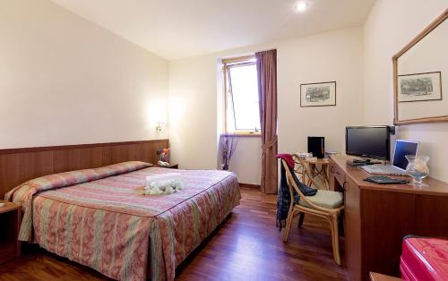 una camera d'albergo con letto e scrivania con computer di Hotel Tivoli a Tivoli Terme