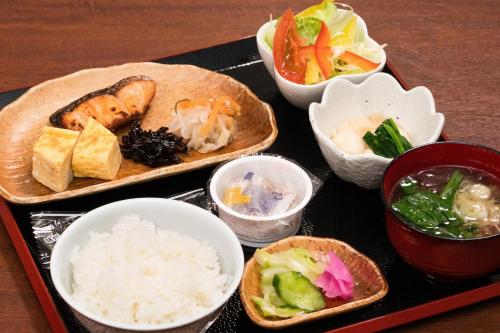 - un plateau de nourriture avec du riz et des bols de nourriture dans l'établissement Hotel Alpha Inn Akita, à Akita