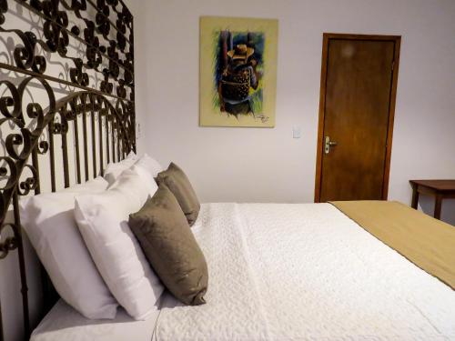 a bedroom with a bed with white sheets and pillows at Casa Perpetua Hotel D Charm in Manaus
