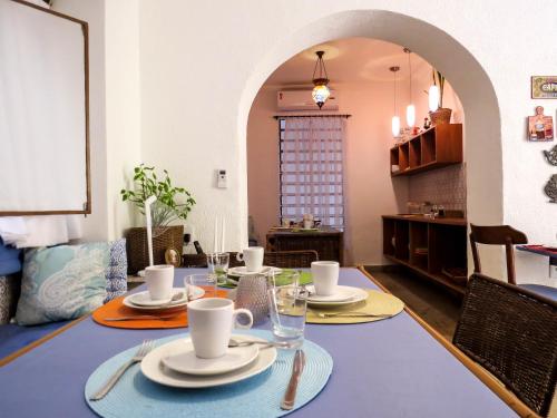 a dining room with a table with plates and cups at Casa Perpetua Hotel D Charm in Manaus