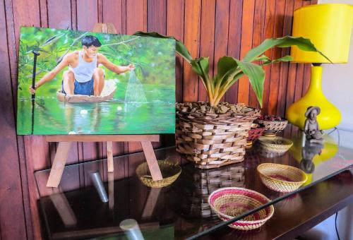 a painting of a woman in the water on a table at Casa Perpetua Hotel D Charm in Manaus