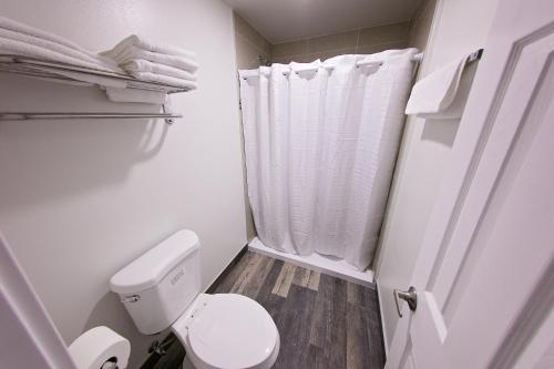 uma casa de banho branca com um WC e um chuveiro em GAREY MOTEL em Pomona