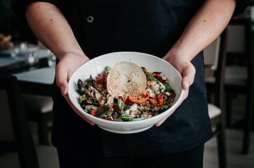 a person holding a bowl of food with their hands at Best Western Hôtel des Thermes - Balaruc les Bains Sète in Balaruc-les-Bains