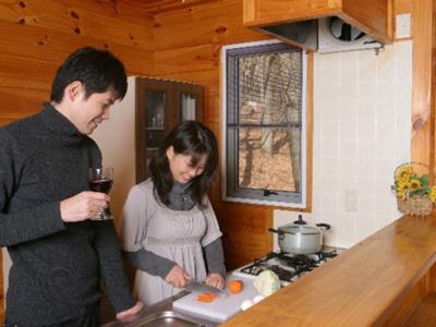 a man and a woman standing in a kitchen at Wan Wan Paradise Tateshina in Tateshina