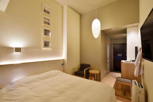 a bedroom with a bed and a chair in it at THE CHELSEA BREATH in Takamatsu