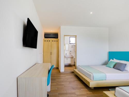 a hotel room with a bed and a tv at Hotel Ojo De Agua in Puerto Morelos