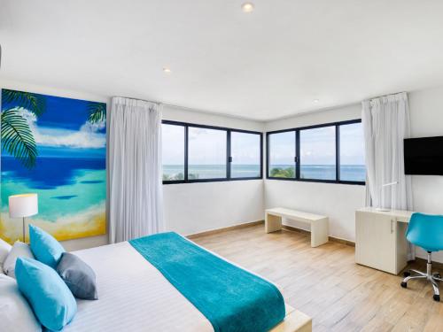 a bedroom with a large bed with blue pillows at Hotel Ojo De Agua in Puerto Morelos