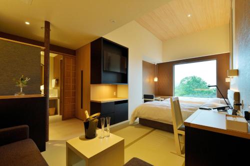 a bedroom with a bed and a desk in a room at THE CHELSEA BREATH in Takamatsu