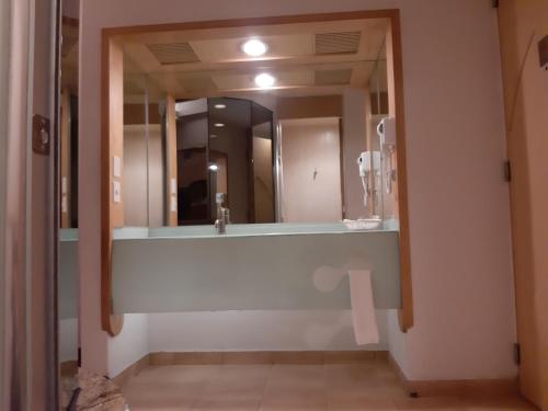 a bathroom with a sink and a large mirror at AUTO HOTEL LEGARIA in Mexico City