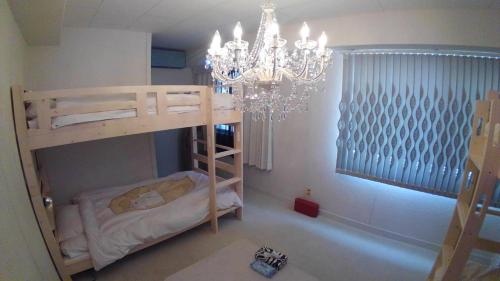 a bedroom with a bunk bed and a chandelier at 女性用 Art Setouchi Triennale Hotel Female Only in Takamatsu