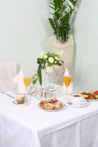 a table with plates of food and glasses of orange juice at Albergo Milano in Boario Terme