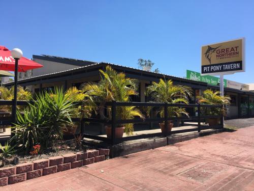 a restaurant with plants in front of a building at Collinsville Motel in Collinsville