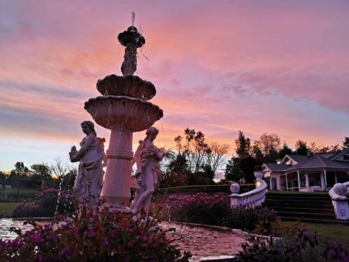 a statue of two women standing next to a fountain at Country Villa Estate in Ngongotaha