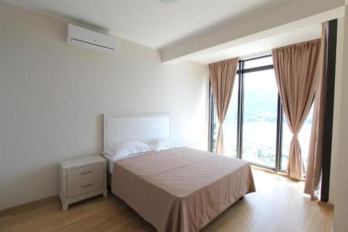 um quarto com uma cama e uma grande janela em Apartments Aqua em Budva