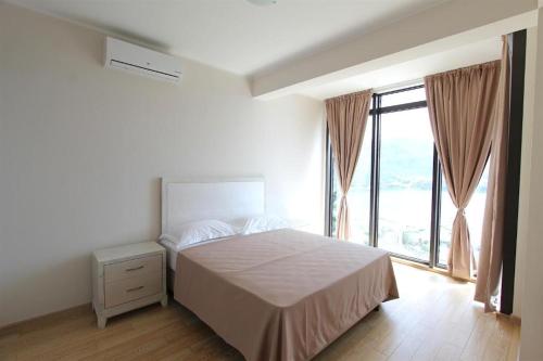 a bedroom with a bed and a large window at Apartments Aqua in Budva