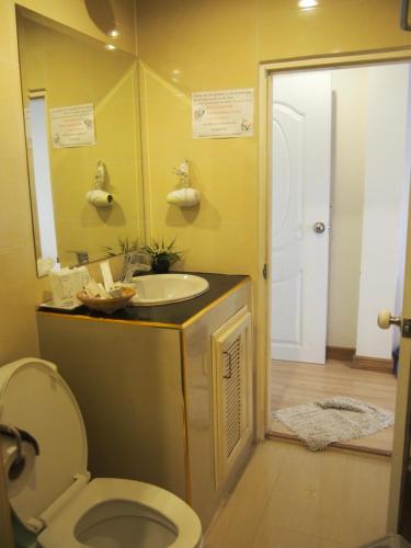 a bathroom with a sink and a toilet and a mirror at Nong Nuey Rooms in Ko Samed