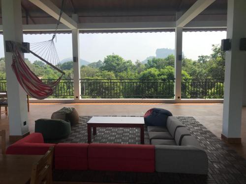 a living room with a couch and a hammock at Iwamisou in Sigiriya