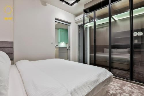a bedroom with a white bed and a window at Expressionz Suites By iHost Global in Kuala Lumpur