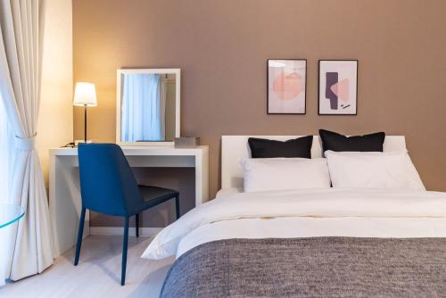 a bedroom with a bed and a desk and a chair at Tino Anastasia in Osaka