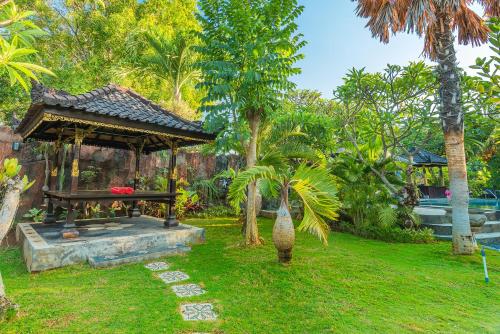 a garden with a gazebo in a yard at Pondok Wisata Sartaya 2 in Lovina