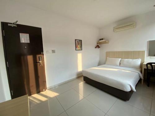 a bedroom with a bed and a desk in a room at Swan Garden Hotel in Pasir Gudang