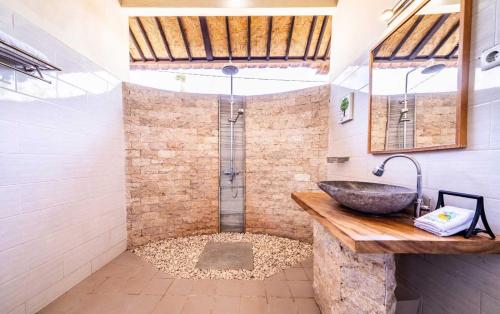 uma casa de banho com um lavatório e um chuveiro em Ocean Sun Dive Resort em Tulamben