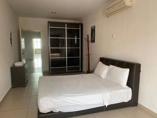 a bedroom with a large bed with white sheets at Swan Garden Hotel in Pasir Gudang