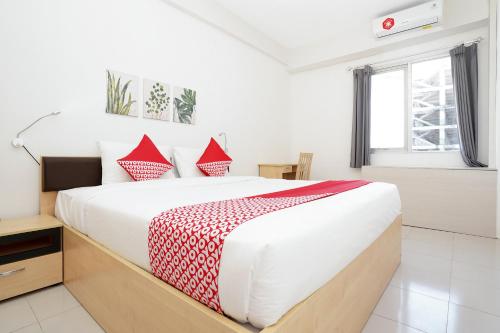 a bed room with a white bedspread and pillows at Vaccinated Staff - OYO Flagship 910 Menara Rungkut Surabaya in Surabaya