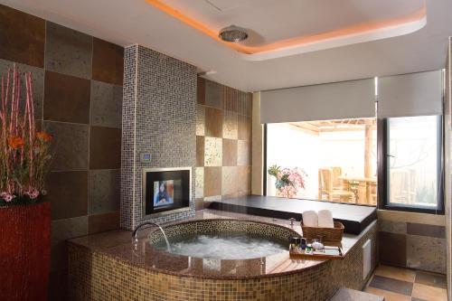 baño con bañera grande y ventana en Chateau Motel & Spa, en Kaohsiung