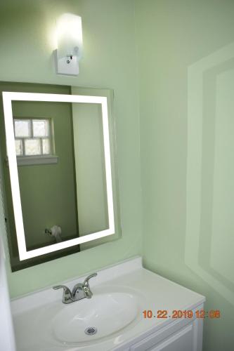 ein Bad mit einem Waschbecken und einem Spiegel in der Unterkunft Belmont Motel in Roswell