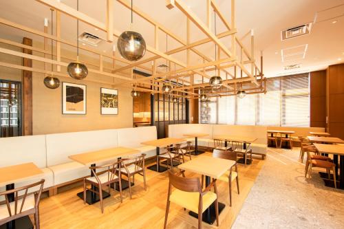 a restaurant with tables and chairs in a room at karaksa hotel grande Shin-Osaka Tower in Osaka