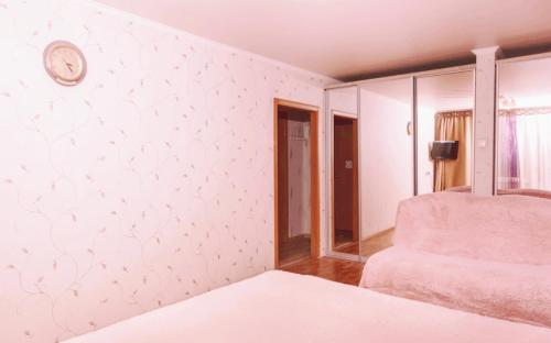 エカテリンブルクにあるApartment For Rentのベッドルーム1室(ベッド1台、壁掛け時計付)