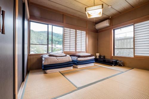 two beds in a room with windows at Classic Japan Living ASAMA in Fujikawaguchiko