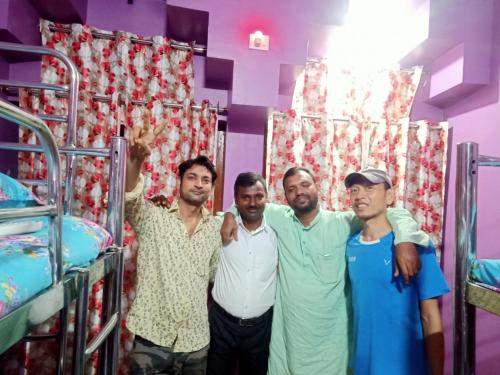 a group of men standing in front of bunk beds at Hostel Relax Homestay in Gaya