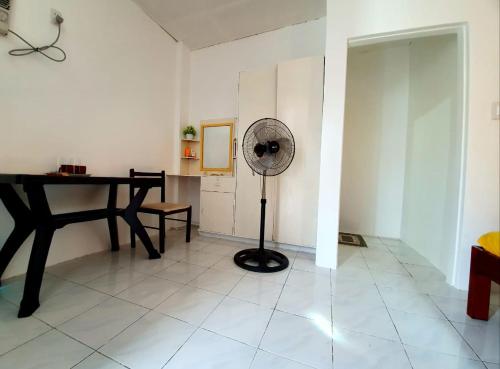 a room with a table and a fan on a floor at Gaja Go Dive & Inn in Moalboal