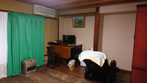 a room with a desk and a green curtain at Live Cafe Hisui no Umi in Itoigawa